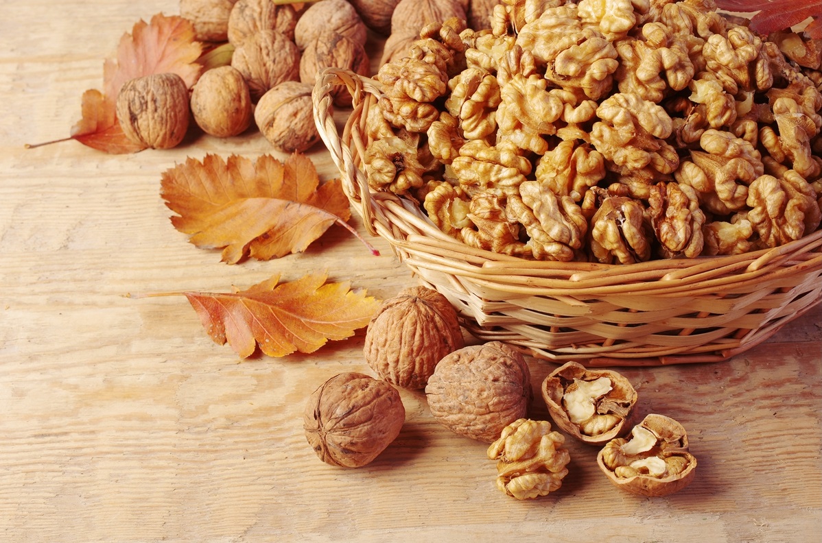 Walnut-kernels-in-basket-and-whole-walnuts-on-rustic-old-wood